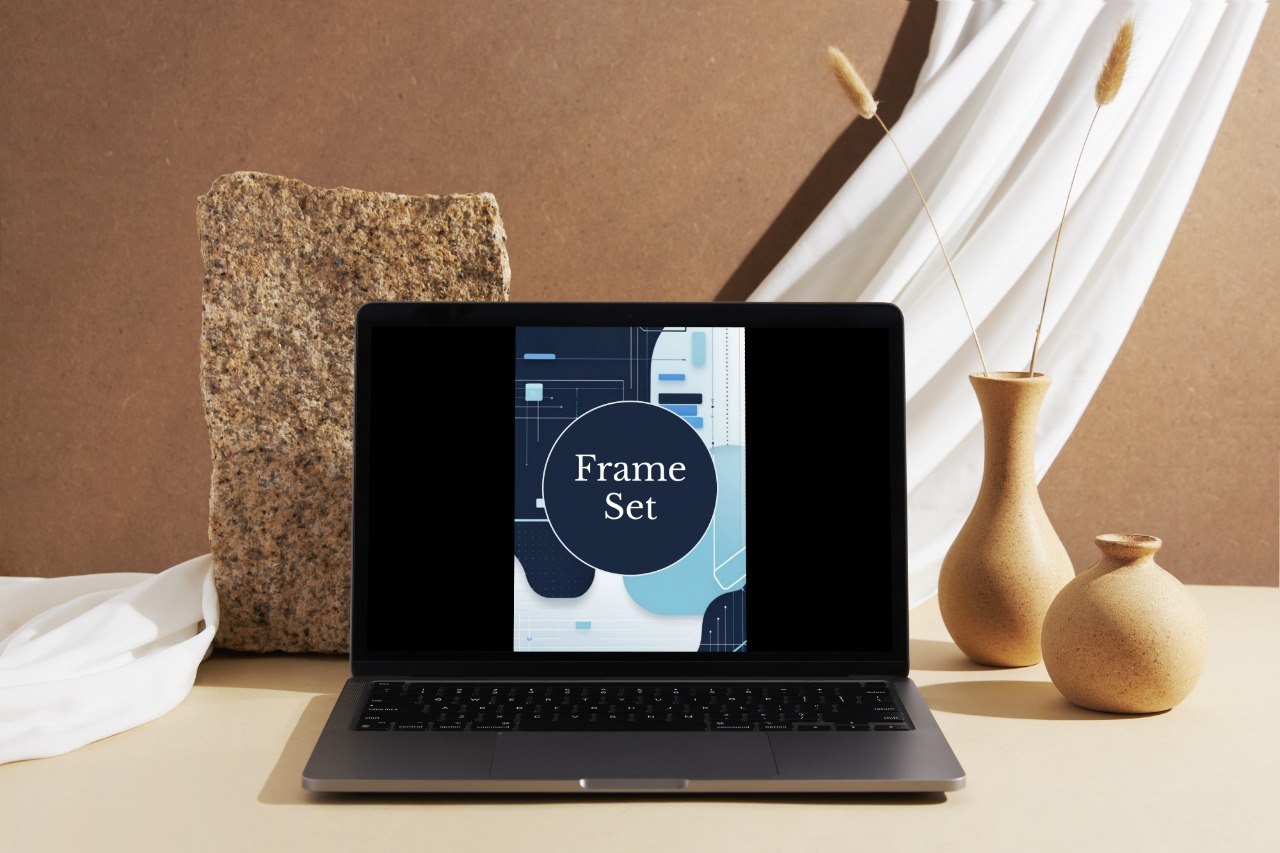 A laptop showing a mockup or design labeled 'Frame Set' over a styled tabletop scene with cream fabric, two tan ceramic vases, and a brown backdrop.